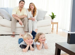 Adorable family watching tv in the living room